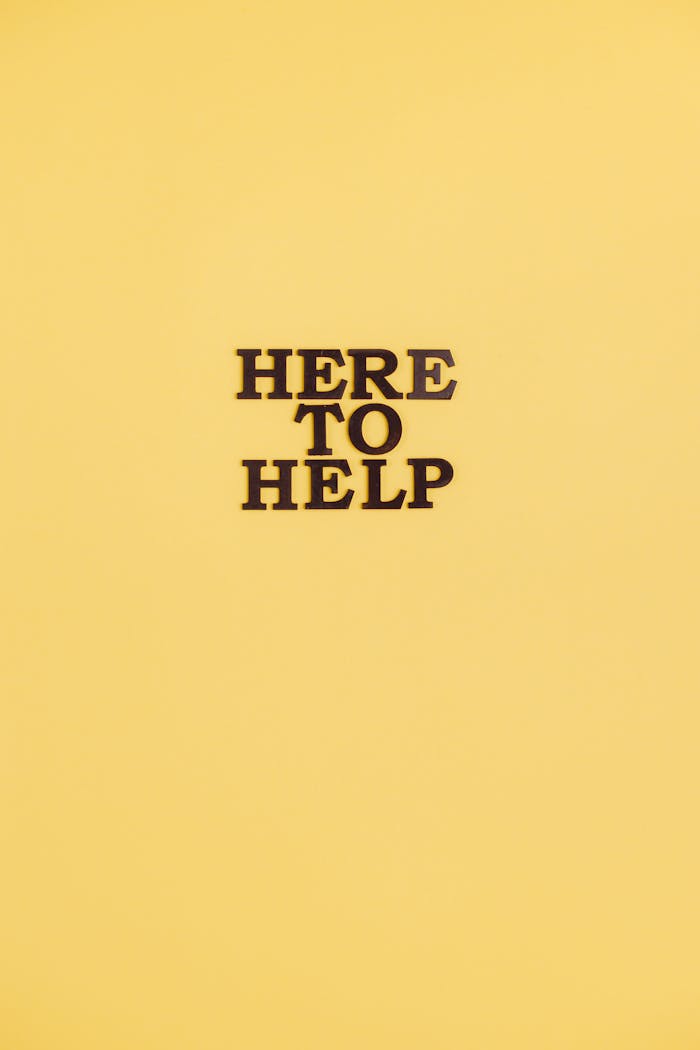 Text 'Here to Help' on a vibrant yellow background offering support.